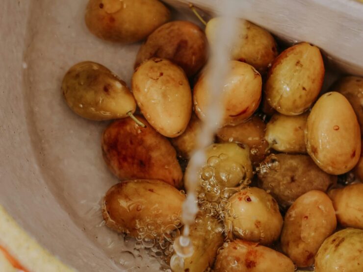 New potatoes in a stone bowl with water running over them
